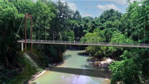 An image of a long concrete pathway wending through Atlanta between neighborhoods beside trees and over creeks. 