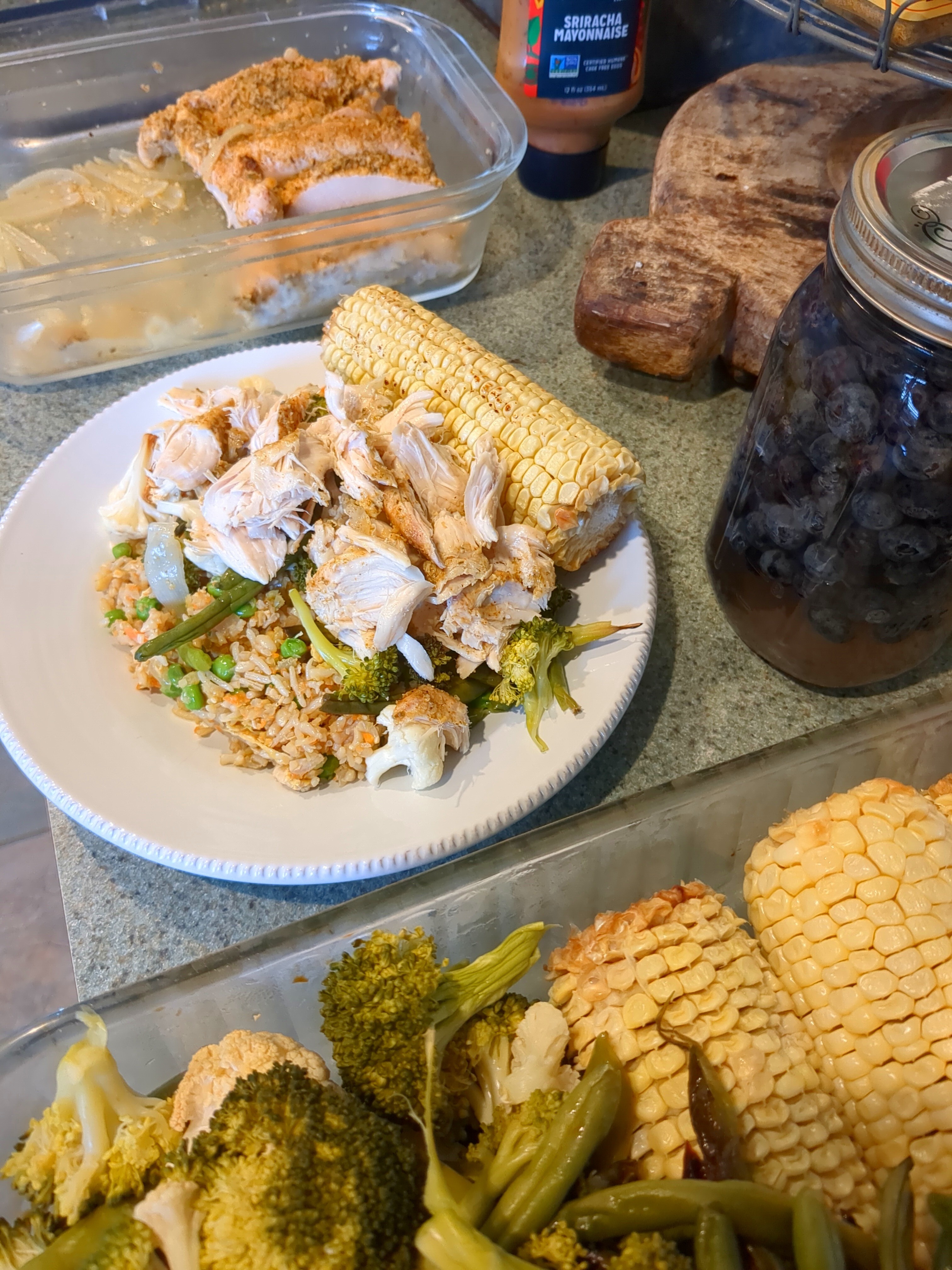 image of a chicken dish on a kitchen counter with a jar of blueberries