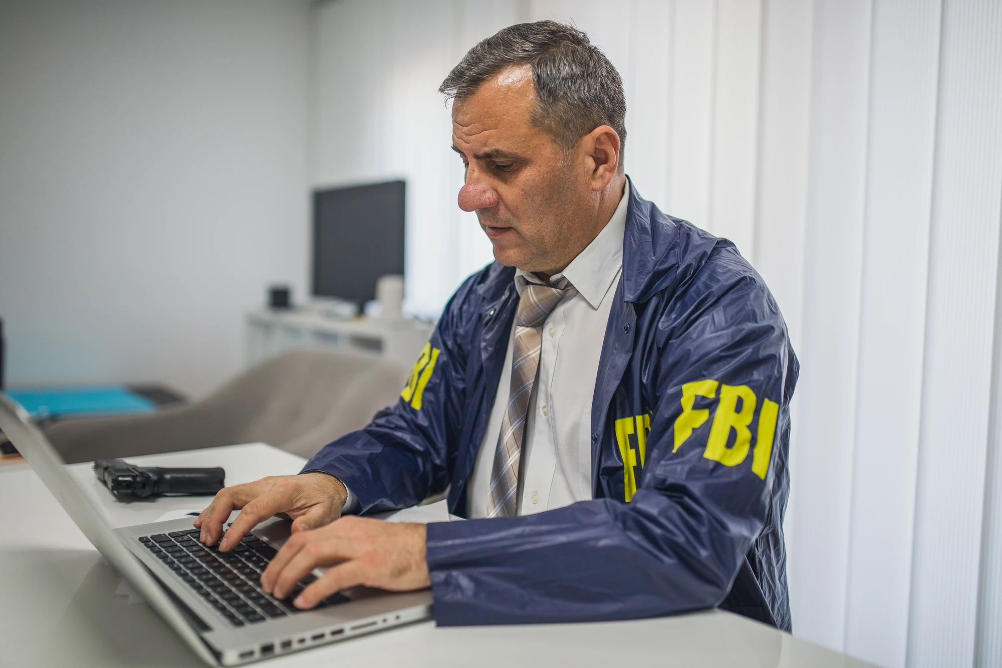 fbi dude typing on a laptop