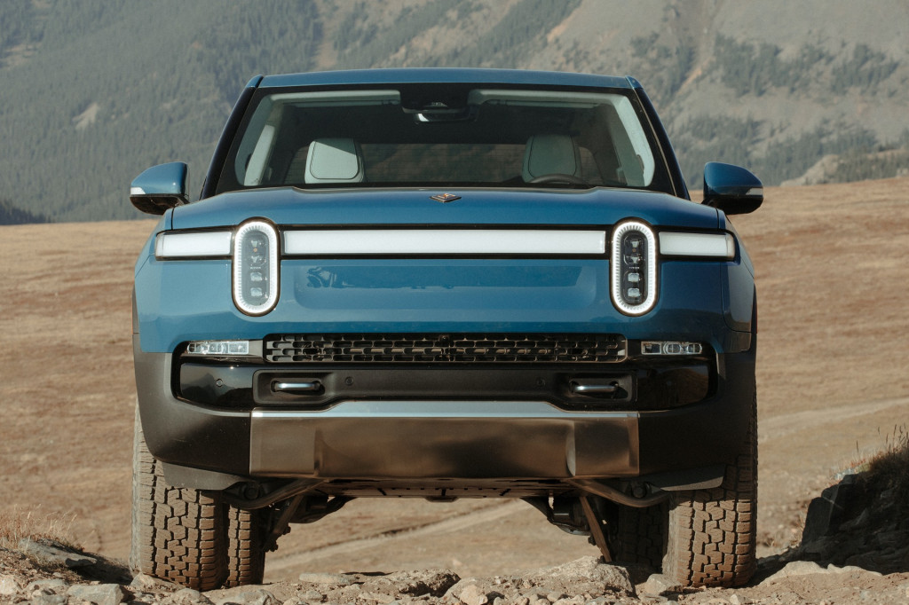A Rivian R1, as seen from straight on, with its dumb little headlights