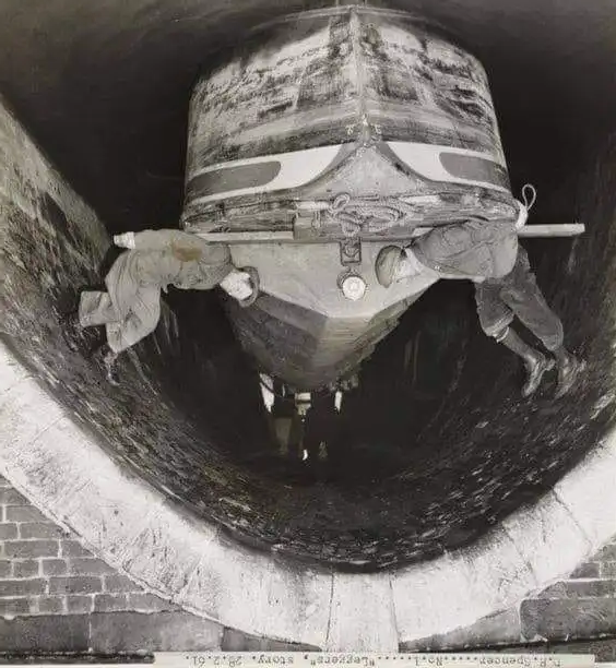 guys legging a boat through a tunnel